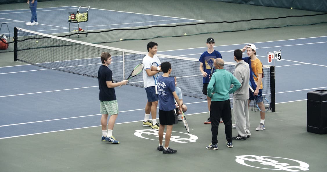 people talking on a tennis court