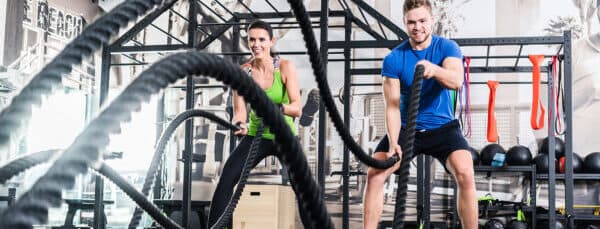 2 people using the ropes at the gym