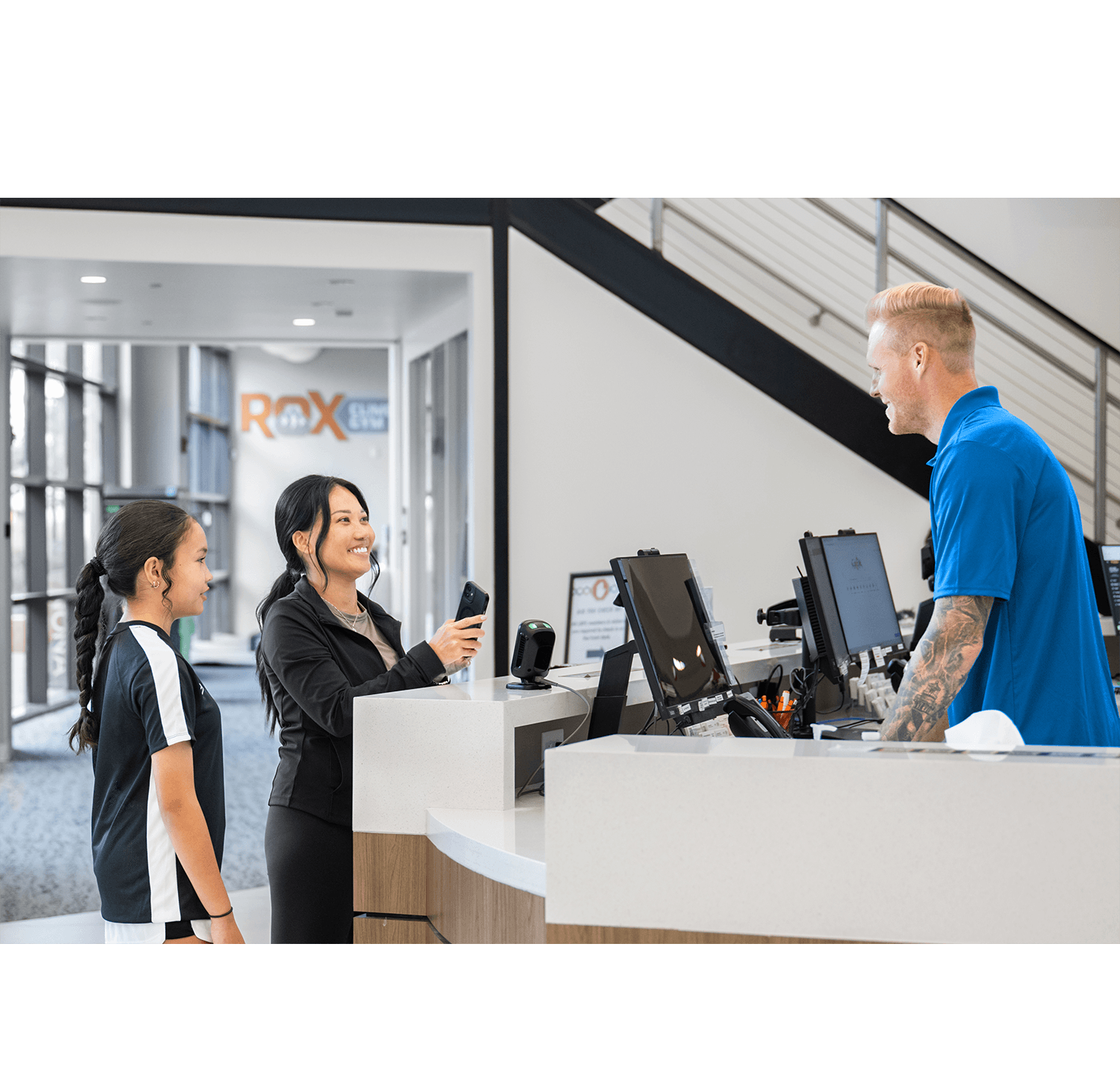 Member scanning mobile credential at a fitness center entry gate using access control software