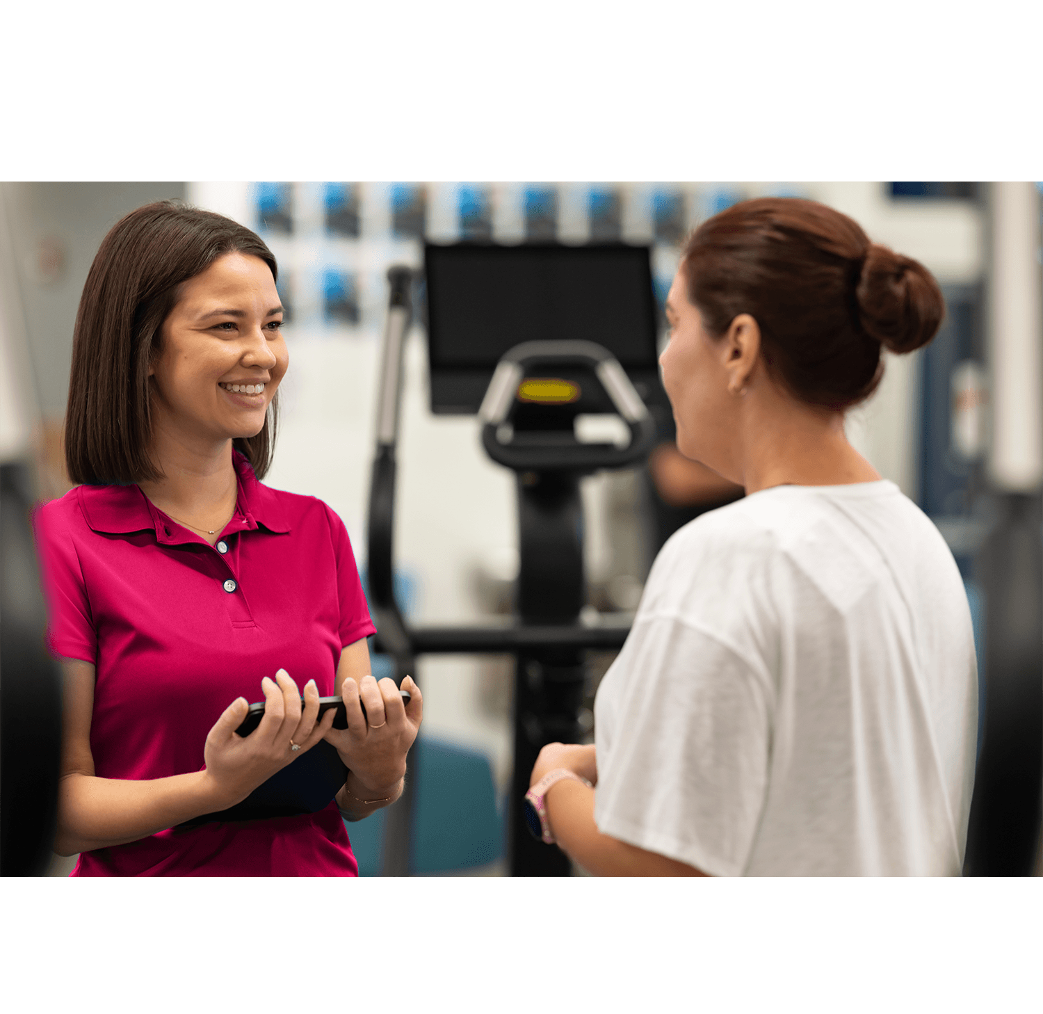 Health club staff member reviewing a family account with linked profiles and consolidated billing in membership software
