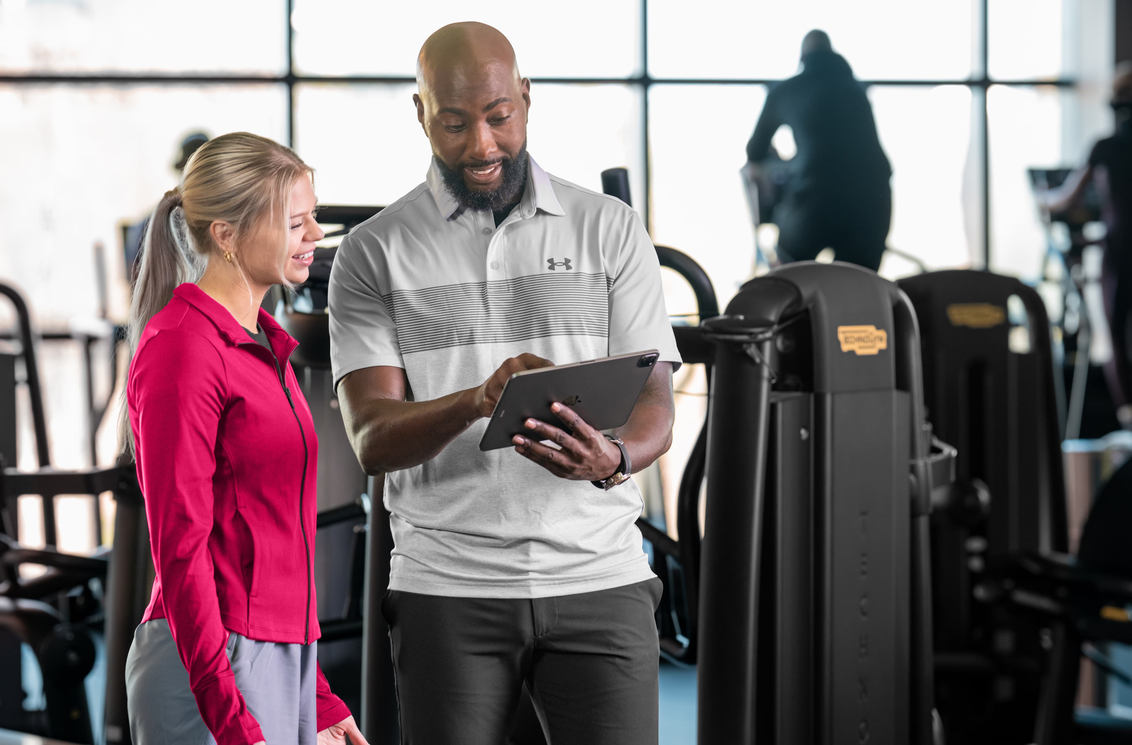 Staff managing multi-location fitness club operations using modern software dashboard.