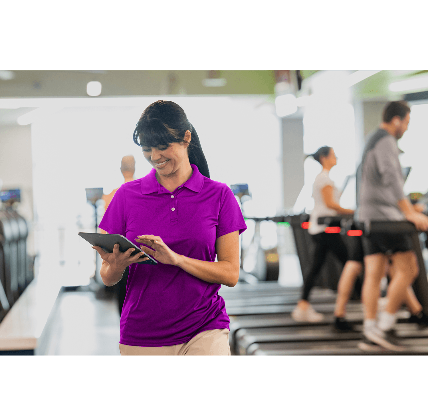 Gym staff using Club Automation gym CRM software on a tablet to manage member relationships at a multi-location health club