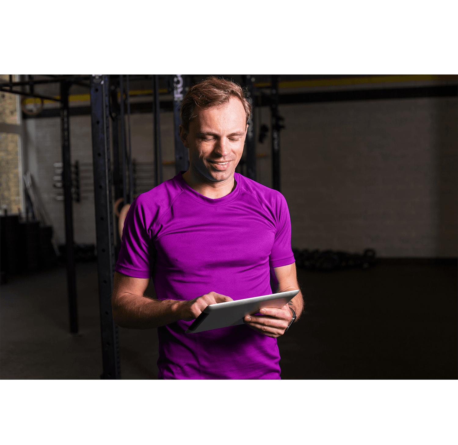 Gym staff using Club Automation modern scheduler on a tablet showing a unified calendar of classes, personal training, and pool sessions at a multi-purpose fitness club